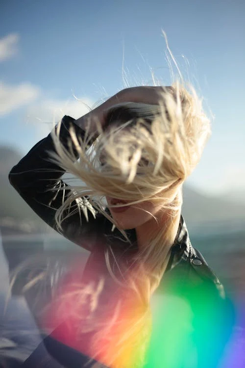 Foto di una ragazza bionda con i capelli al vento