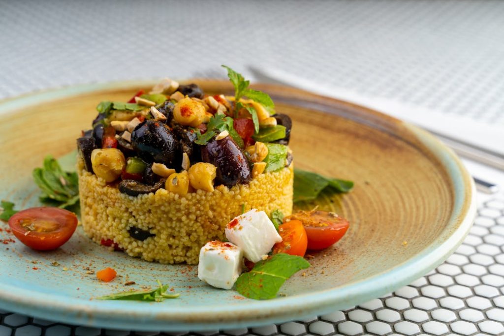 Foto di un piatto con del couscous ben guarnito con delle verdure sopra