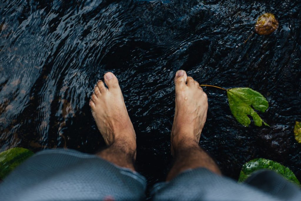 Foto presa dall'alto di piedi scalzi dentro l'acqua